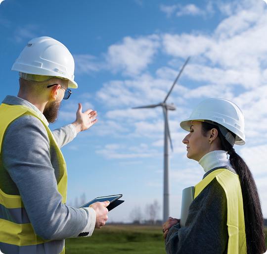 Project staff in safety vests discussing a wind project on site